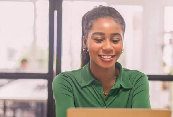 Female practice owner looking at computer for their practice growth checklist.