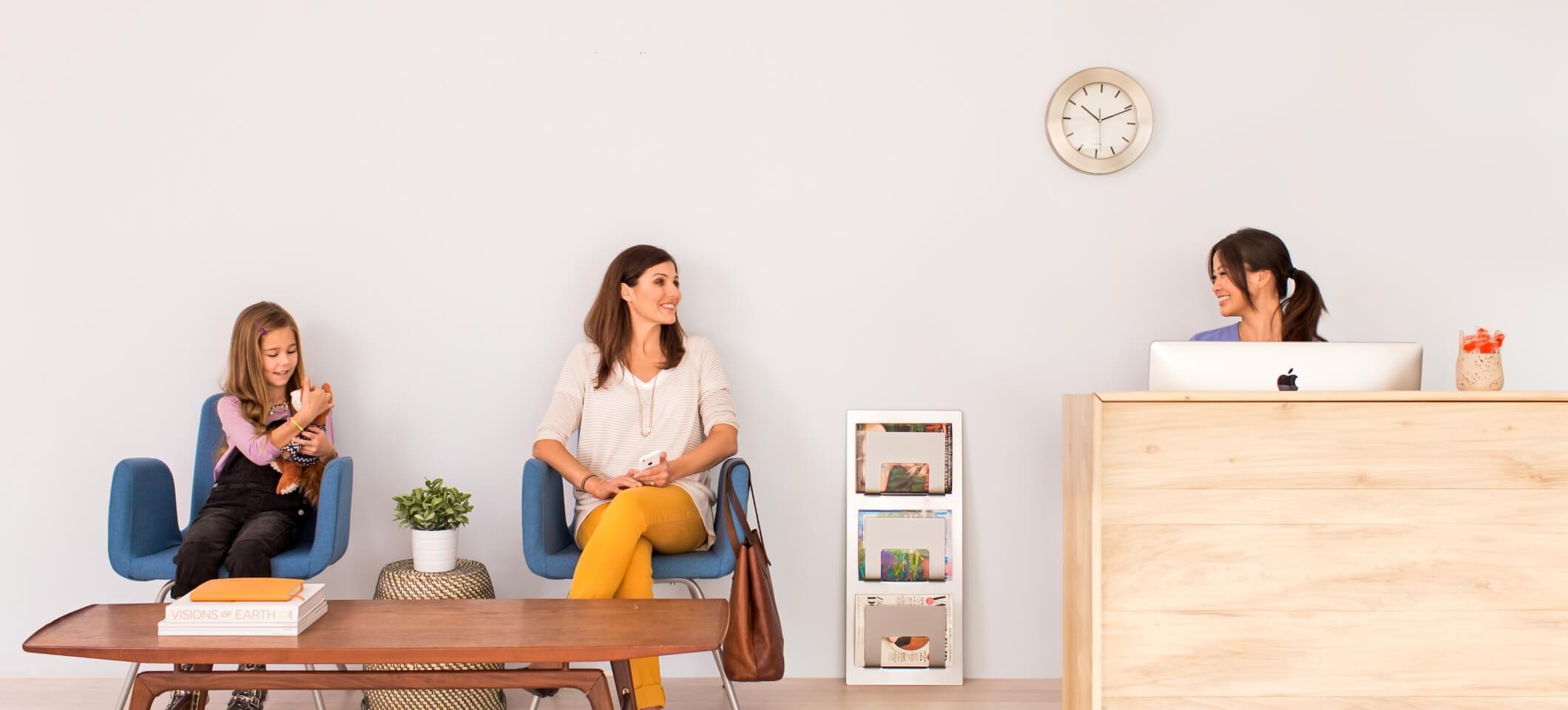 Mother and daughter waiting in doctor's office waiting room