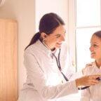 Physician using stethoscope and using clinic equipment on patient