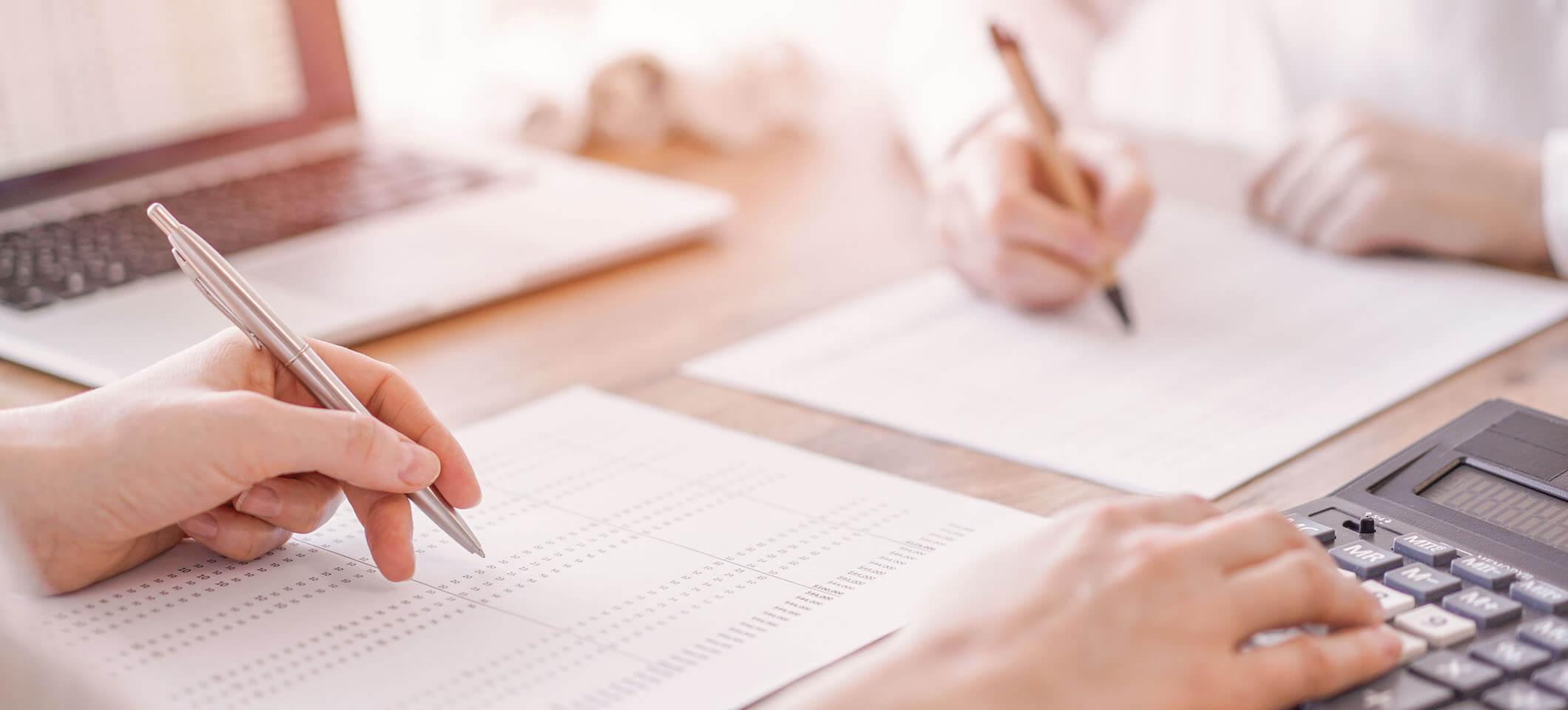 a left white hand holding a silver pen to show how handwritten-appearing signatures can enhance direct mail marketing