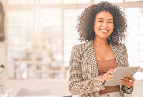 Medical practice manager smiles while holding tablet