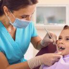 Dentist helps child patient on National Dentist Day