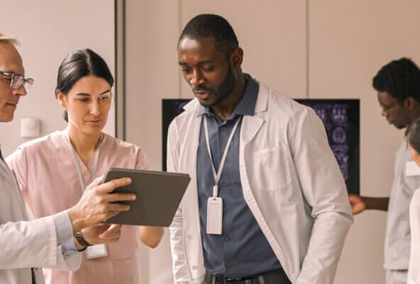 Doctors look at a tablet strategizing about their physician marketing plan