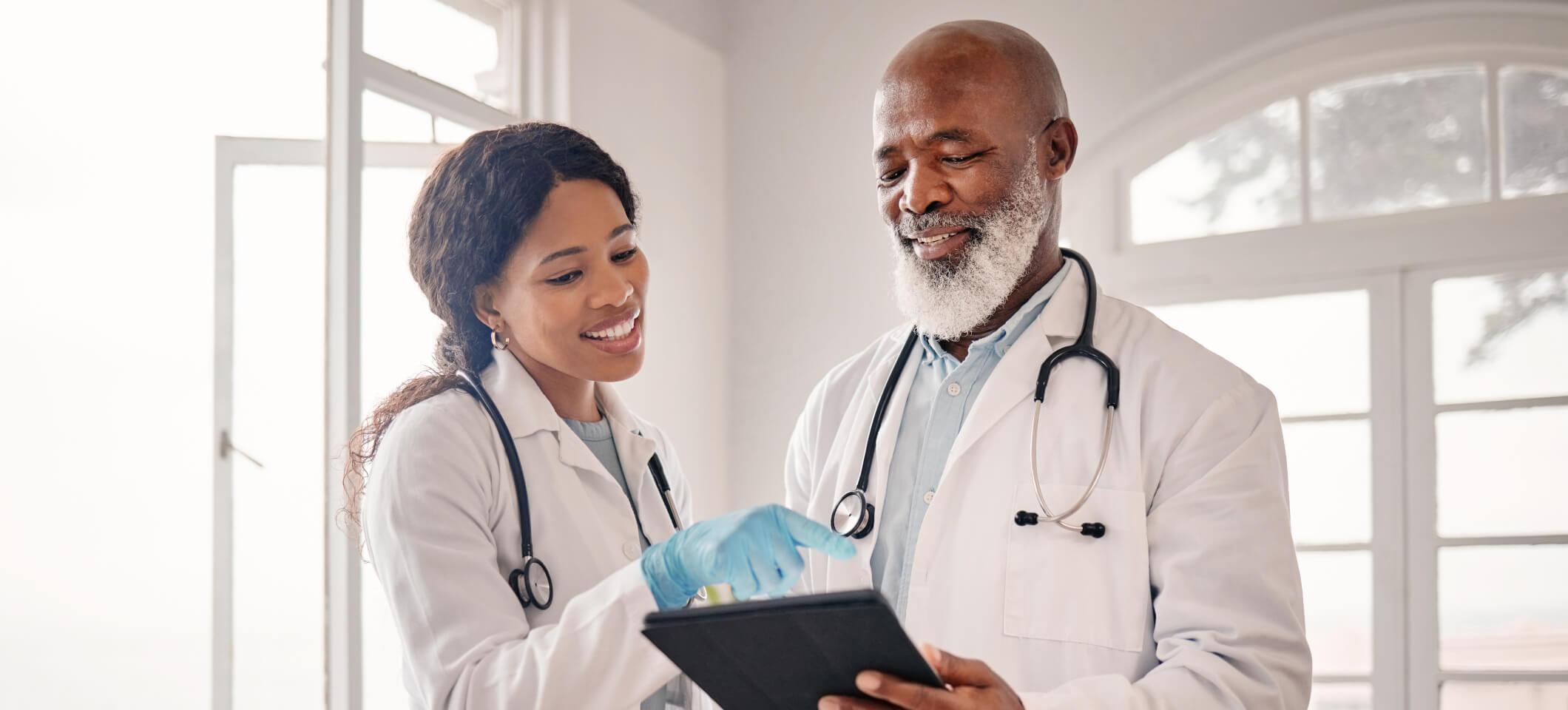 Physicians discuss their medical practice marketing budget while looking at tablet