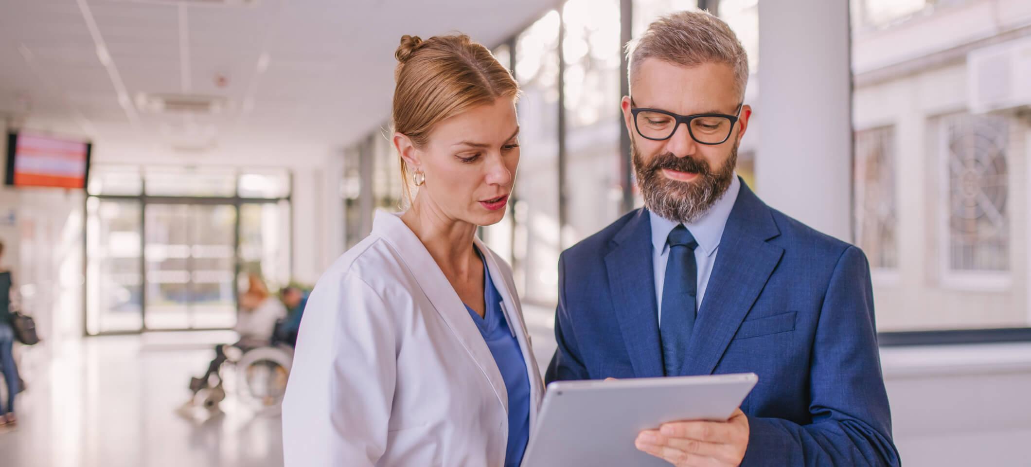 Physicians discuss cost transparency in healthcare while looking at tablet
