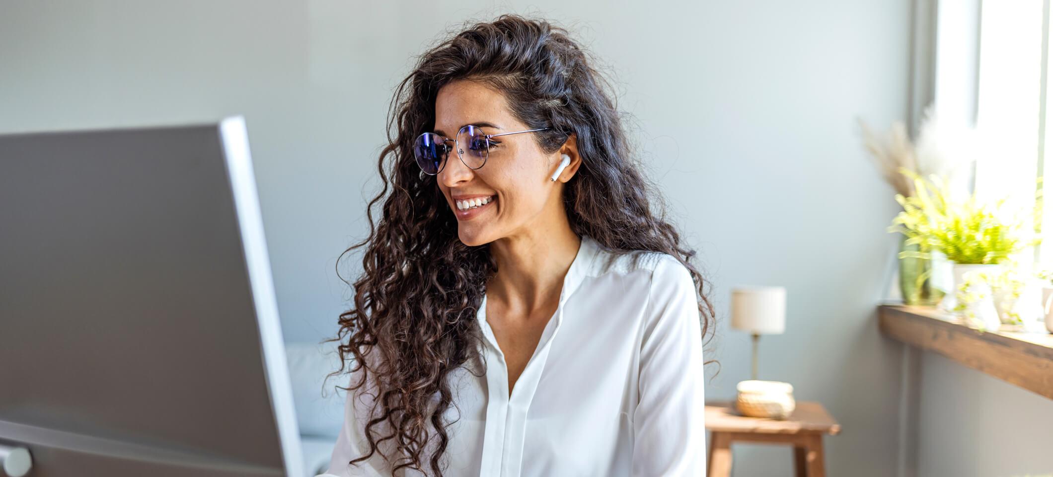 Medical practice manager smiles while reading about medical coding updates 2025 on computer
