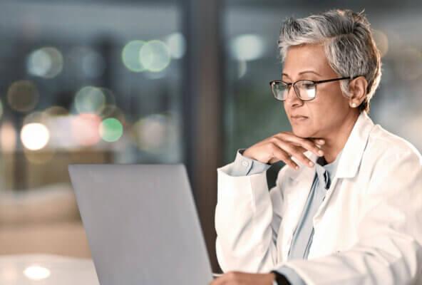 Physician reads article on computer explaining "what is EMR"