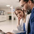 Physician and vendor discuss EHR cost while looking at tablet