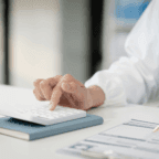 doctor pictured using calculate to calculate mental health services