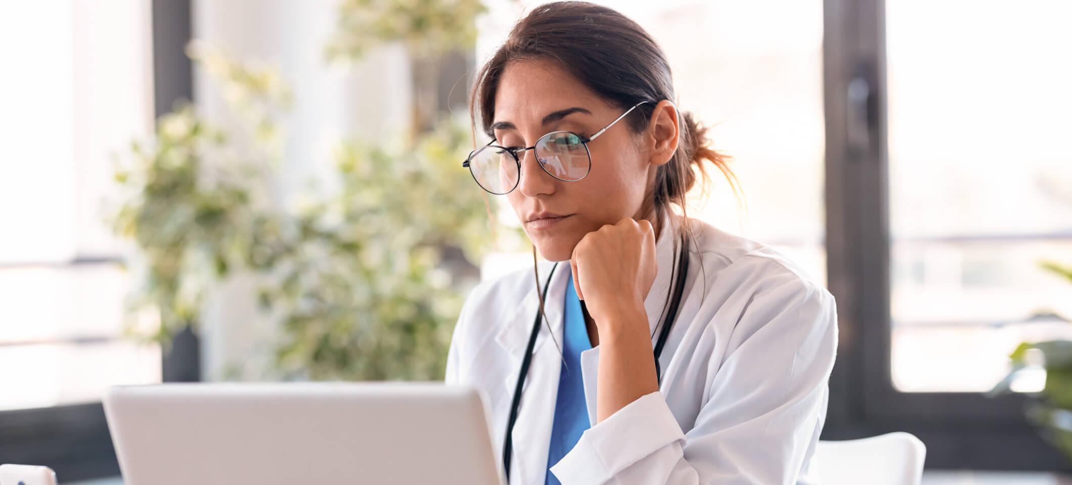 Physician reads on computer about HIPAA breach notification rule