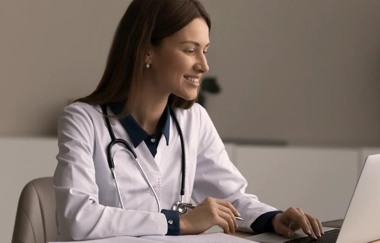 female healthcare professional looking at laptop