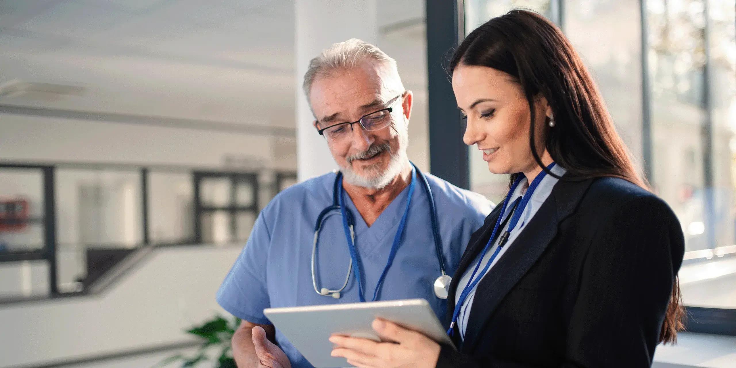 healthcare professionals collaborating while looking at EHR on their tablet