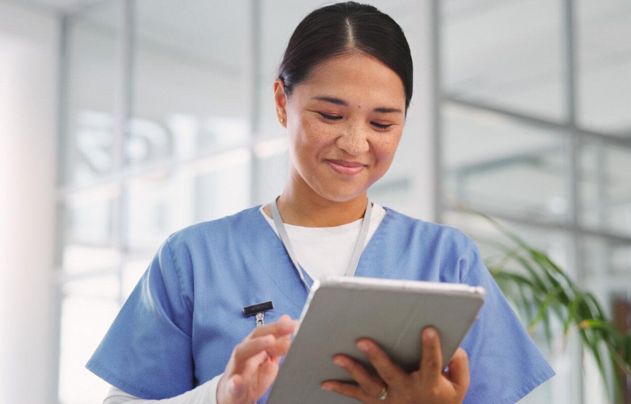Nurse smiles while working with eRx software on tablet