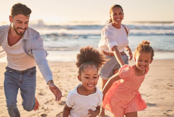 Family on beach observes UV Safety Month as part of July healthcare observances