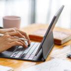 Person typing on keyboard looking up medical billing software cost