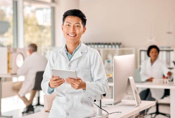 A provider who optimized their EHR with AI, holding a tablet.