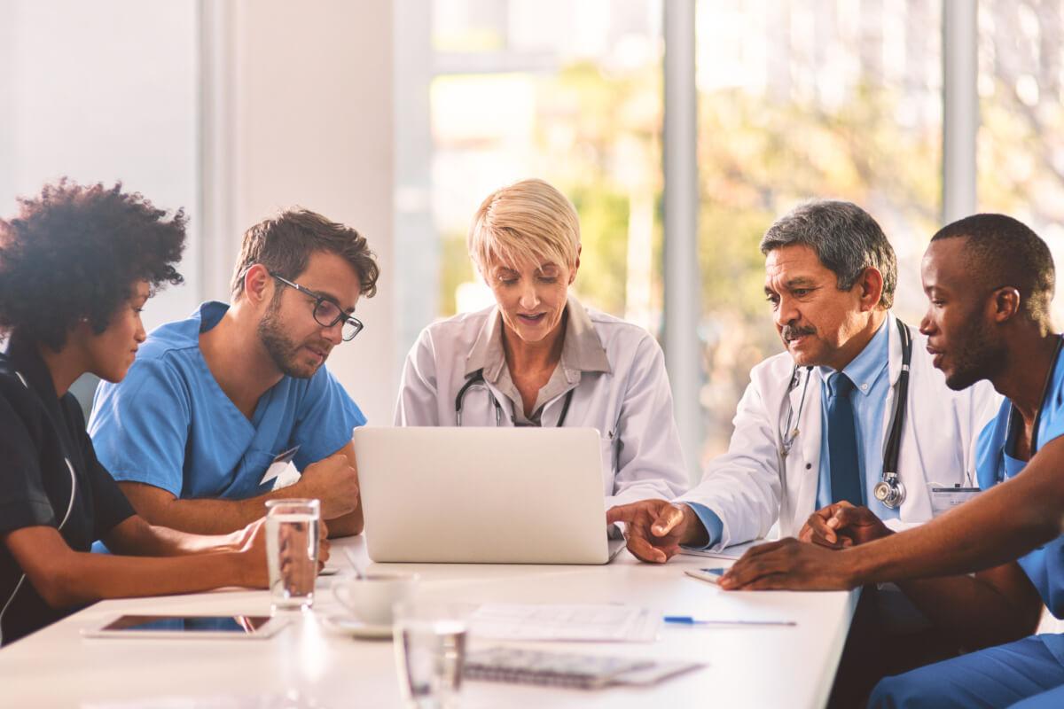 Independent medical practice team looks at computer and discusses how patients use online reviews