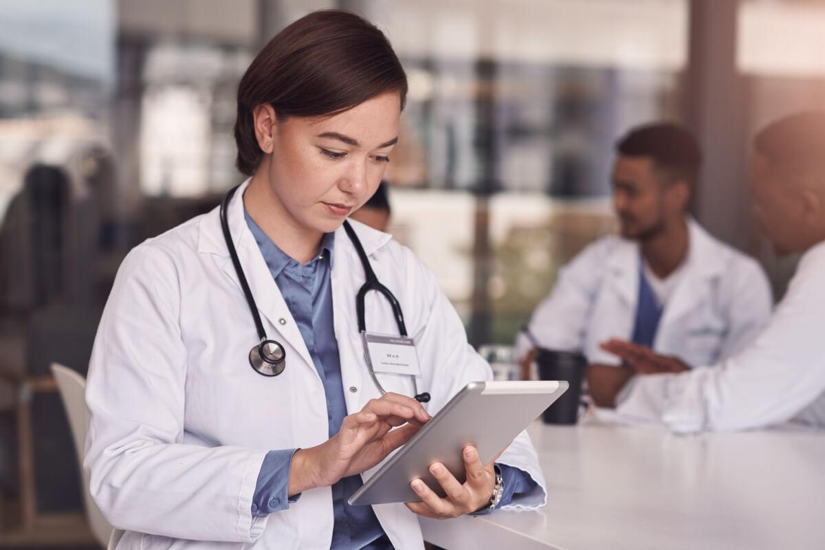 Physician looks at data on tablet as part of healthcare remote patient monitoring
