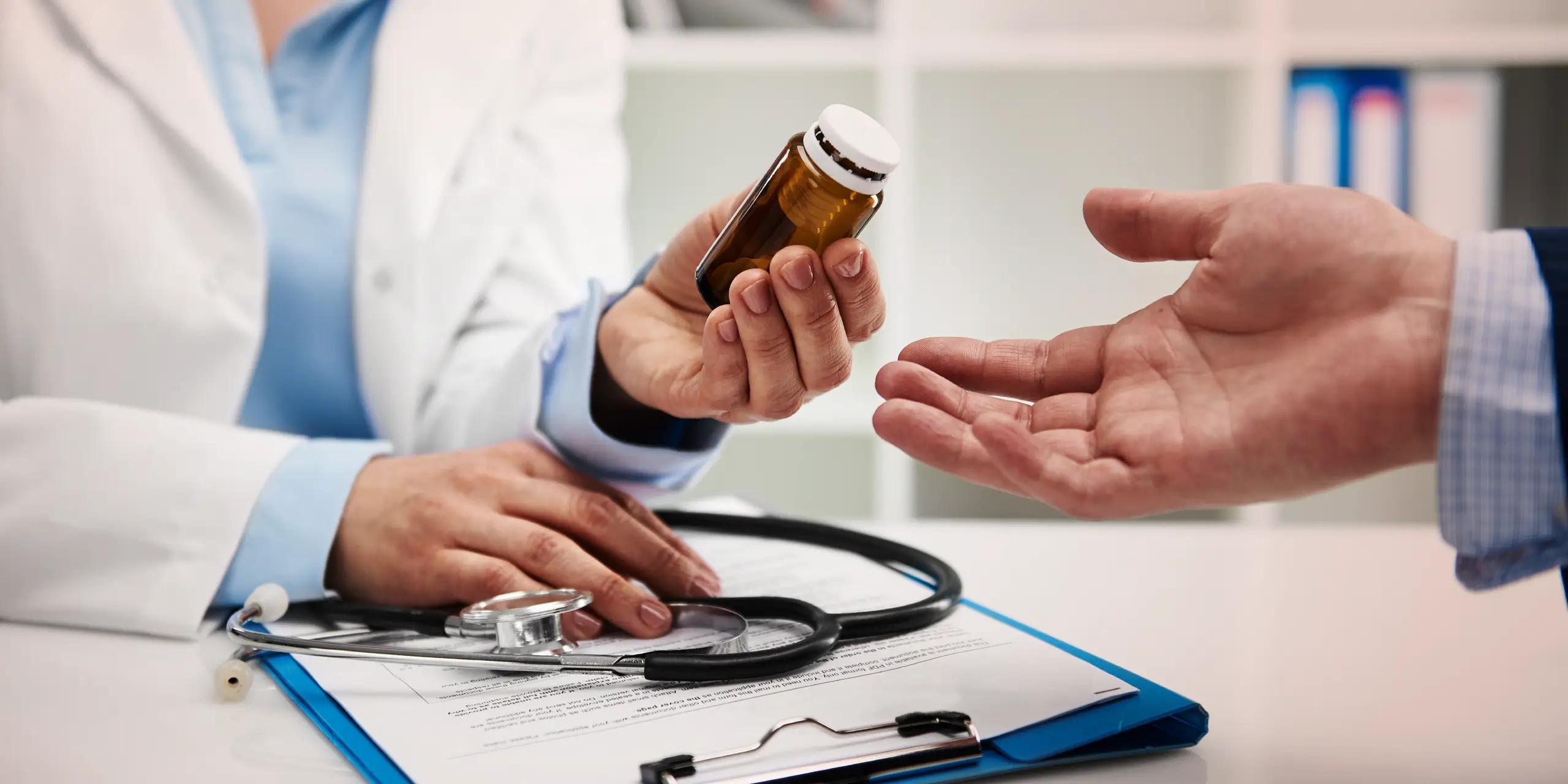 Healthcare provider holding a supplement bottle while discussing usage with a patient during a medical consultation.