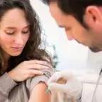 Healthcare provider administering a flu shot to a patient’s upper arm during a clinic visit.