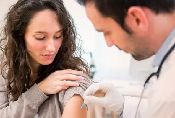 Healthcare provider administering a flu shot to a patient’s upper arm during a clinic visit.