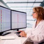 Medical biller looks at computer while navigating healthcare payer challenges