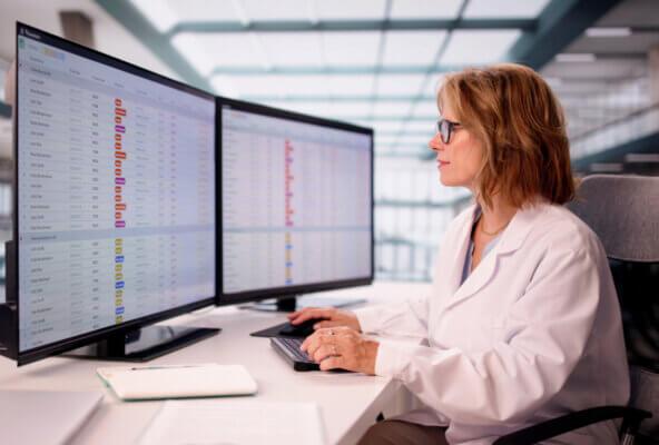 Medical biller looks at computer while navigating healthcare payer challenges