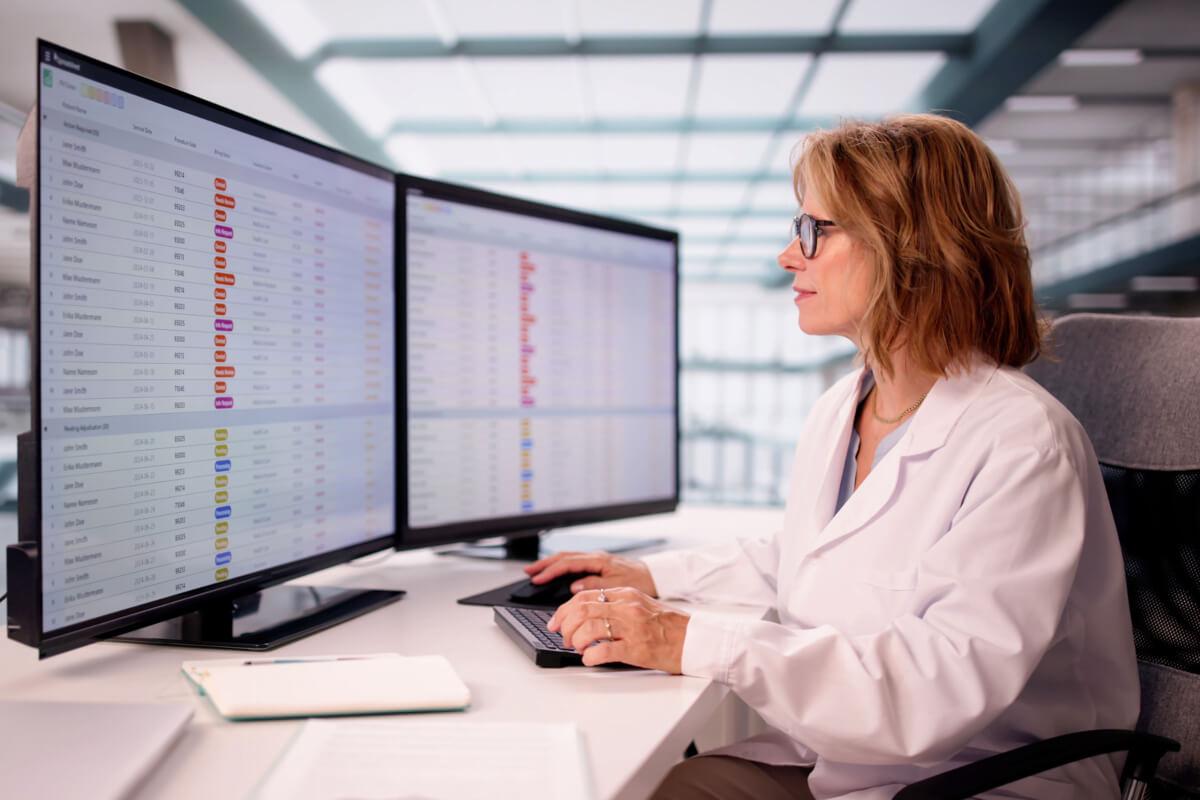 Medical biller looks at computer while navigating healthcare payer challenges