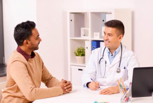 Doctor and patient smile and talk while exemplifying why patients stay rather than why patients leave their doctor
