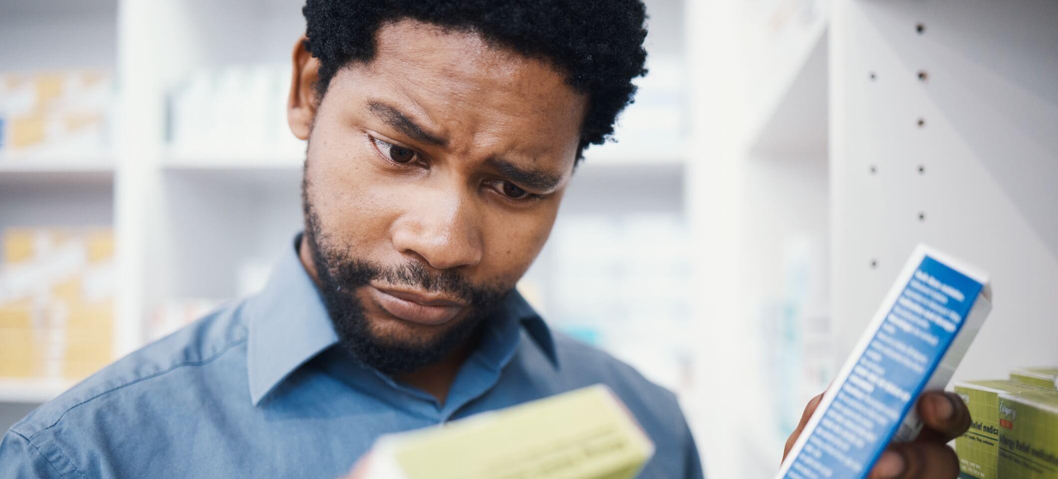 person looking at boxes of medicine looking confused
