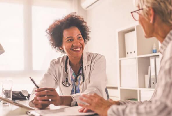physician smiling and speaking to practice staff member