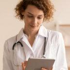 This is an image of a doctor reading information on a tablet screen.