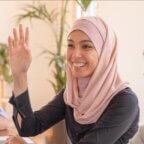 smiling employees at healthcare staff meeting discussing employee retention