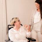 two healthcare professionals, one in a wheelchair and one standing, brainstorming how to boost patient engagement