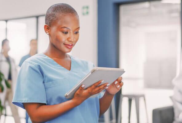a Black doctor using a tablet to take steps to protect patient privacy