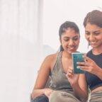 Two women looking at social media on a smartphone.