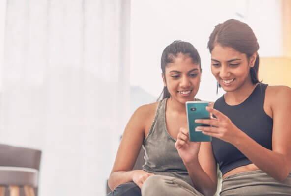 Two women looking at social media on a smartphone.
