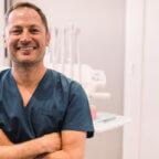 Smiling dentist poses for photo for his dental social media