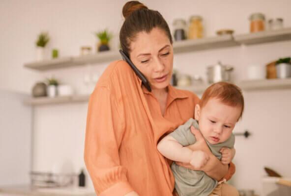 Mom holding toddler son is on the phone as one of the healthcare communication channels