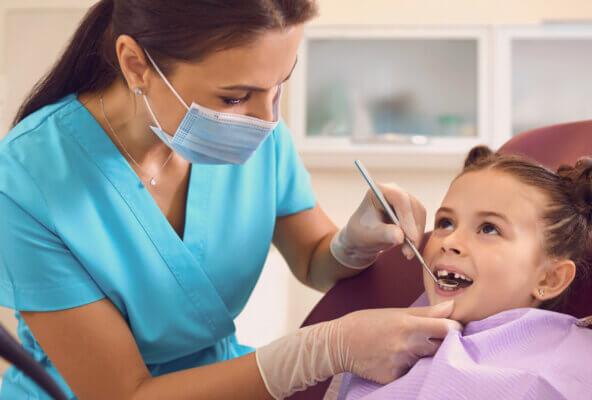 Dentist helps child patient on National Dentist Day