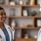 Physician smiles and greets a patient for an appointment after digital patient engagement