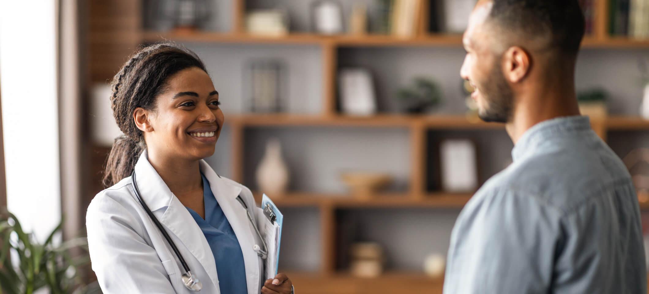 Physician smiles and greets a patient for an appointment after digital patient engagement