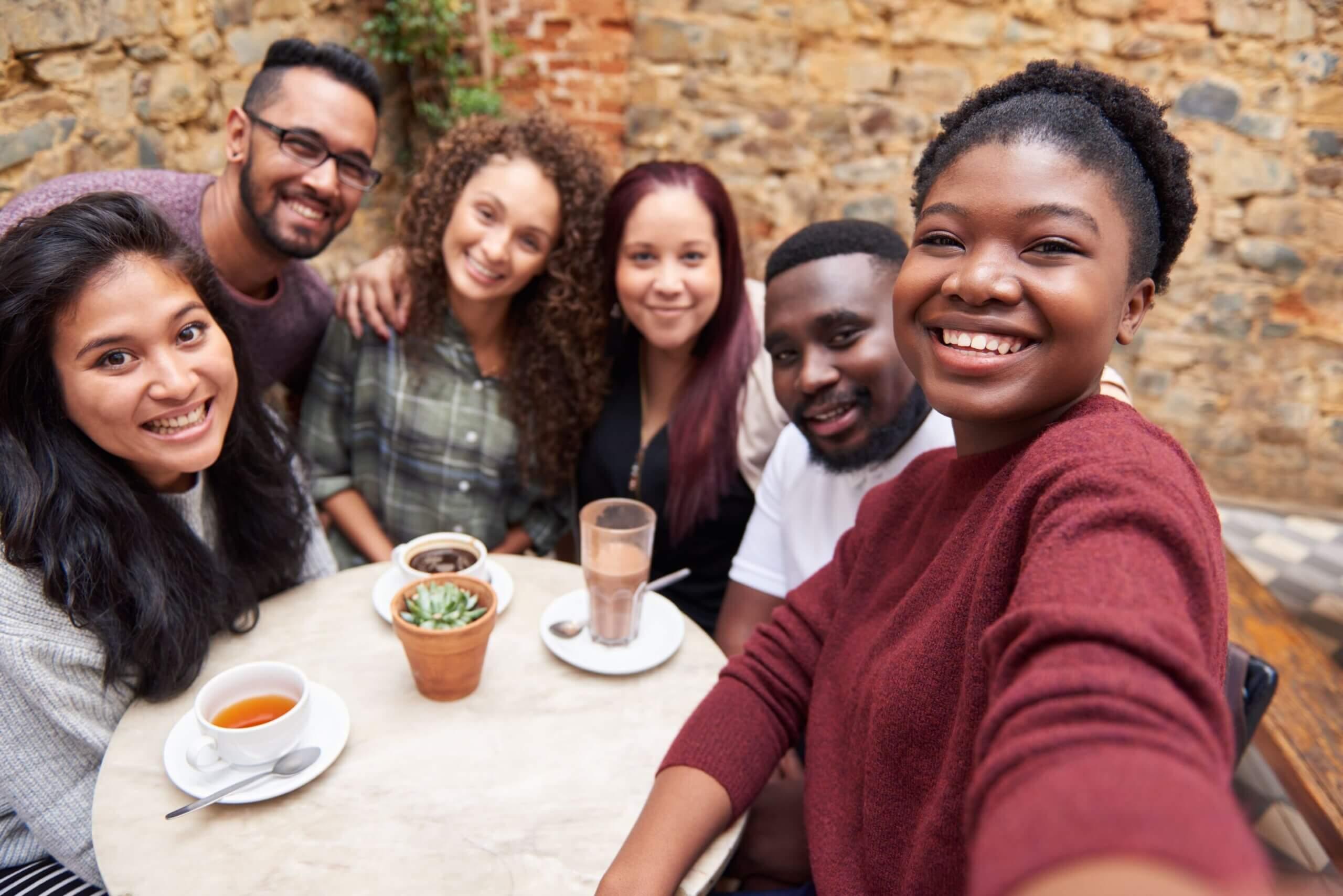 Multicultural group smiling while sitting at a table
