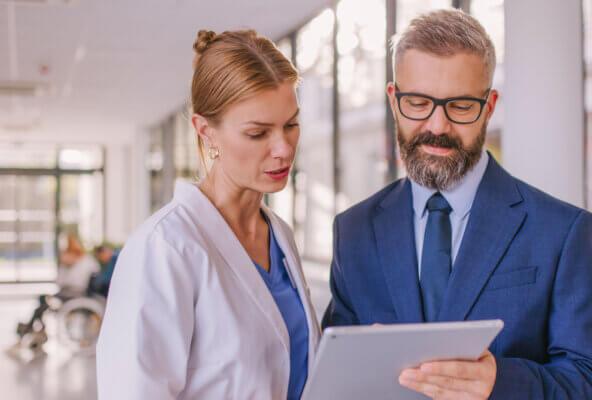Physicians discuss cost transparency in healthcare while looking at tablet