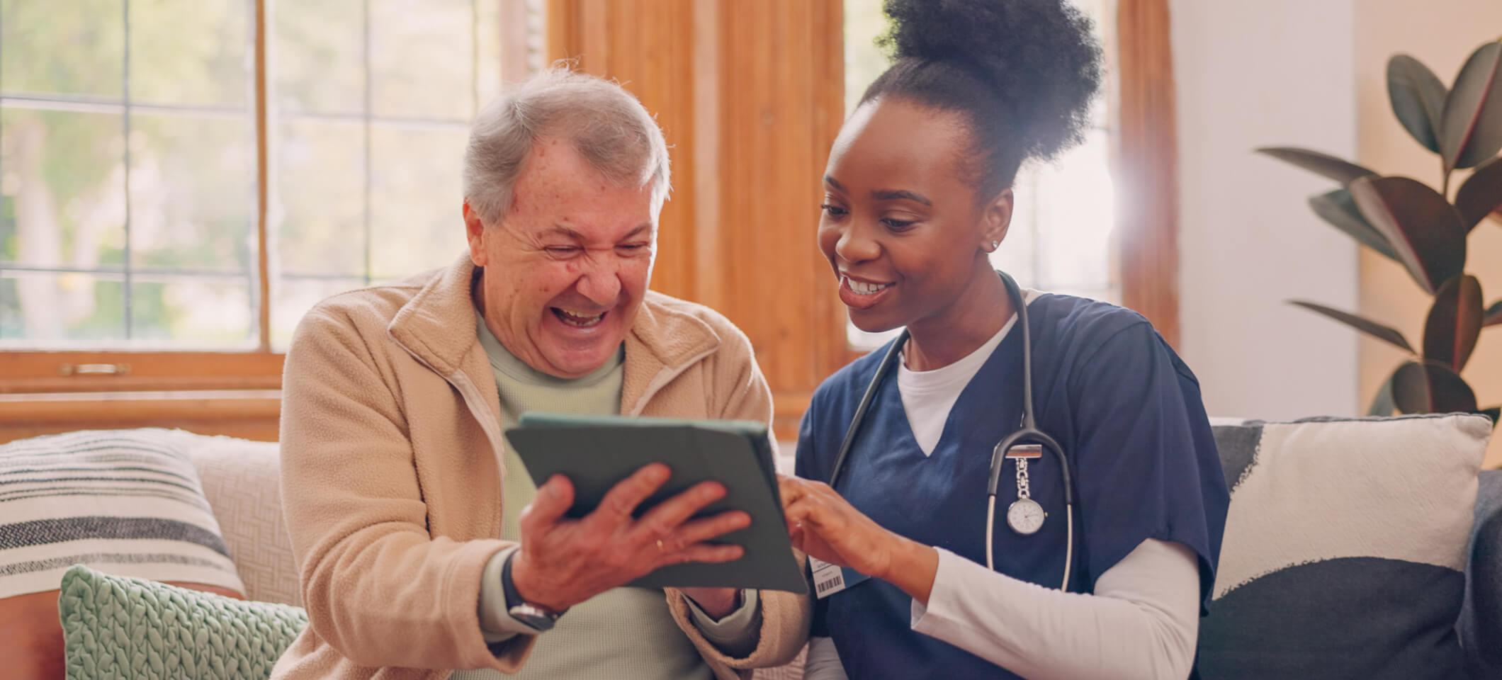 Staff member demonstrates how to improve customer service at your medical practice by helping patient with intake on tablet