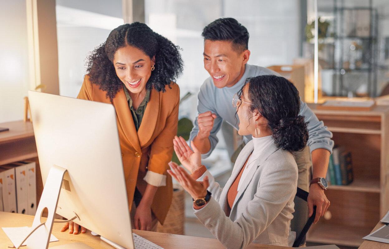 3 colleagues look at computer and celebrate as they get new medical billing business
