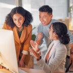 3 colleagues look at computer and celebrate as they get new medical billing business