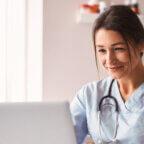 Physician smiles in office while reading holiday season checklist for independent practices