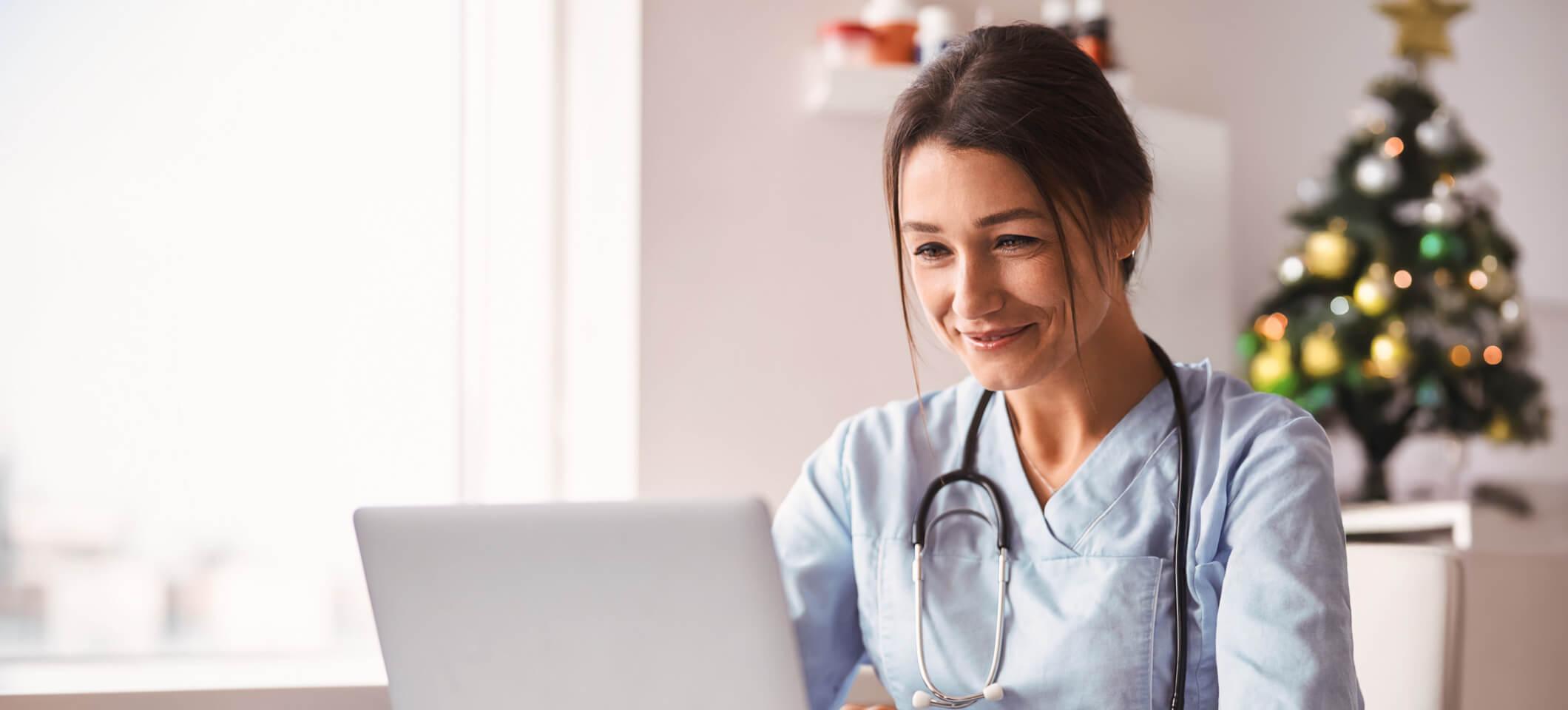 Physician smiles in office while reading holiday season checklist for independent practices