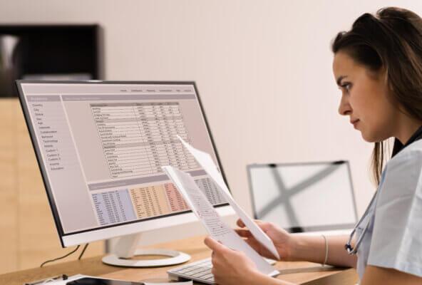 Physician looks at billing paperwork considering how to choose the best medical billing software
